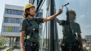 Nettoyage de vitrerie professionnelle en hauteur à Argenteuil — opératrice BDN Nettoyage en harnais sécurisé sur immeuble tertiaire Val d'Oise (décret 2004-924)